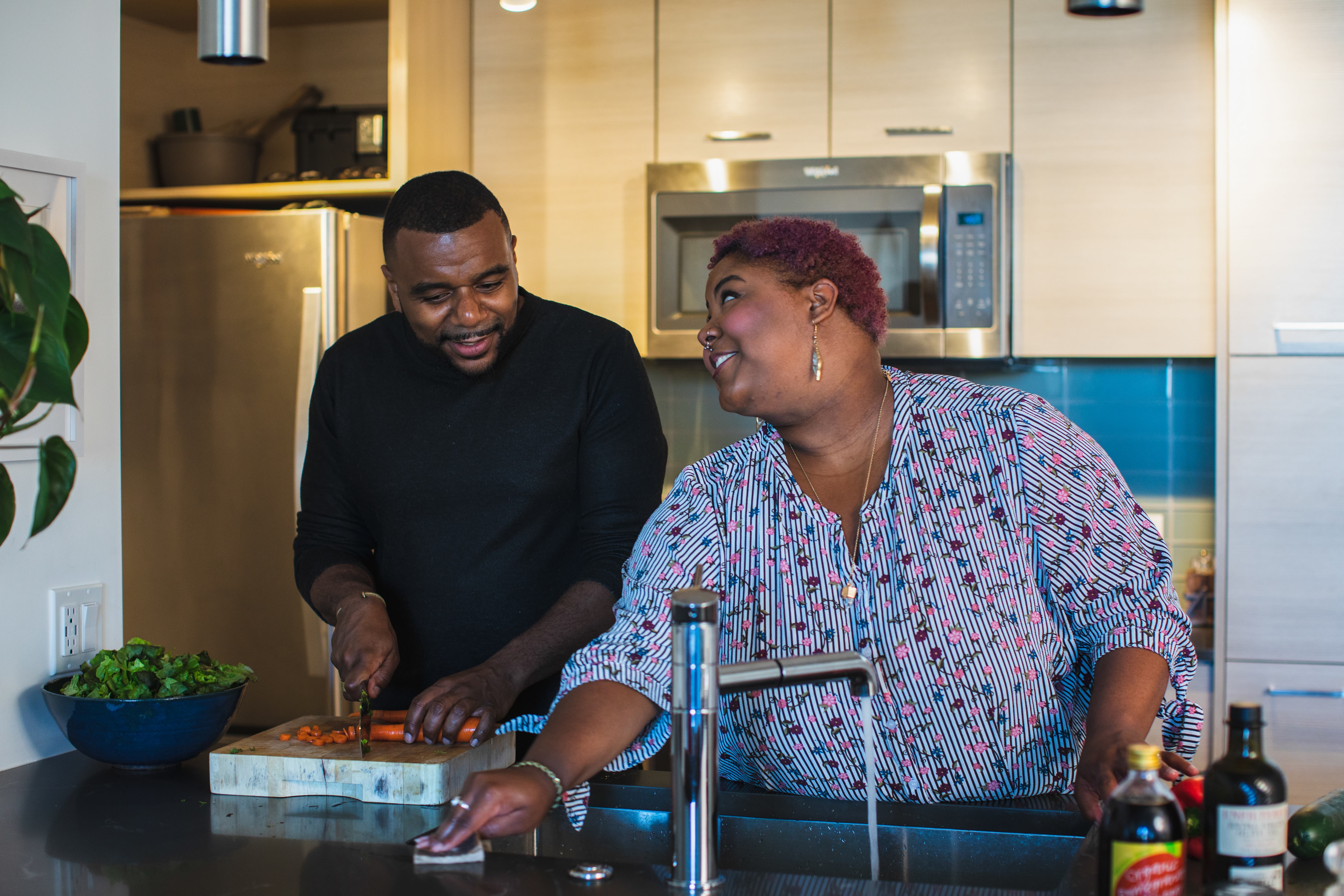 Two people cooking together in a modern kitchen, smiling